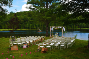 Rows of chairs set up in the grass with lake in the background ready for a wedding ceremony.