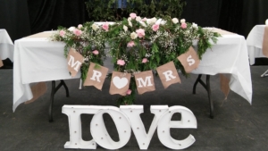 Flower arrangement on a table with signs saying "Love" and "Mr & Mrs"