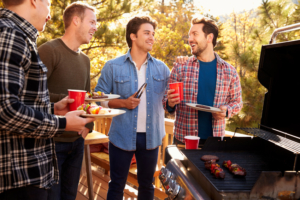 4 men with food and drink at a BBQ